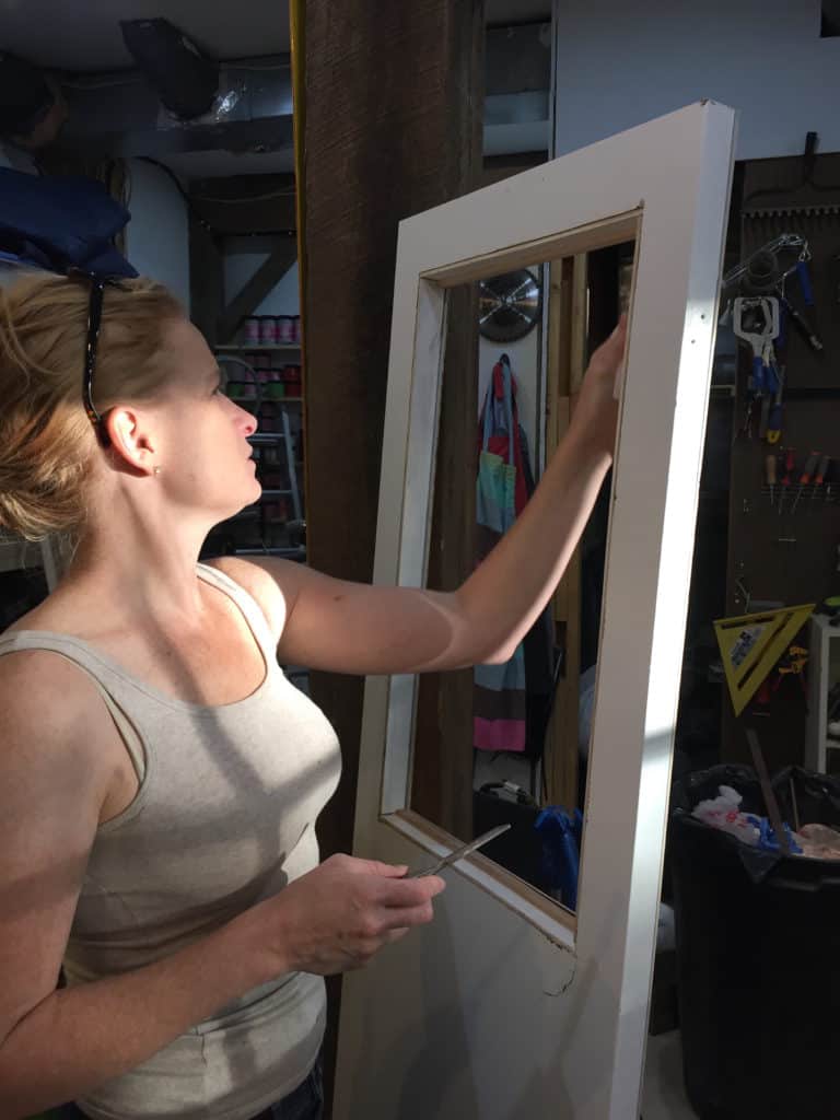 rv remodel office door makeover woman inserting trim for window glass in workshop environment