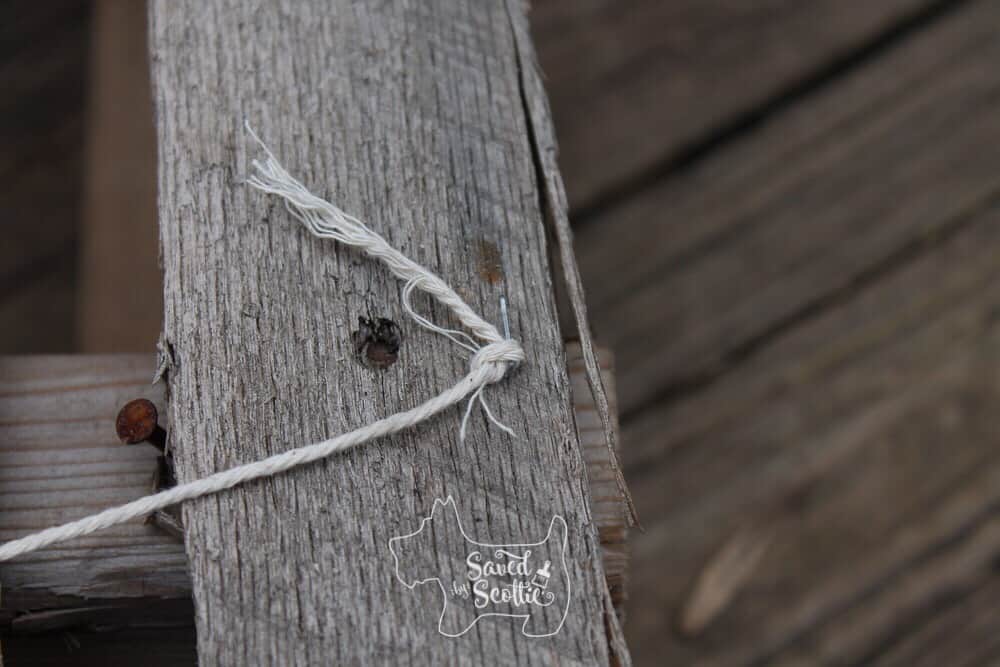 close up of a string stapled to a wood pallet slat