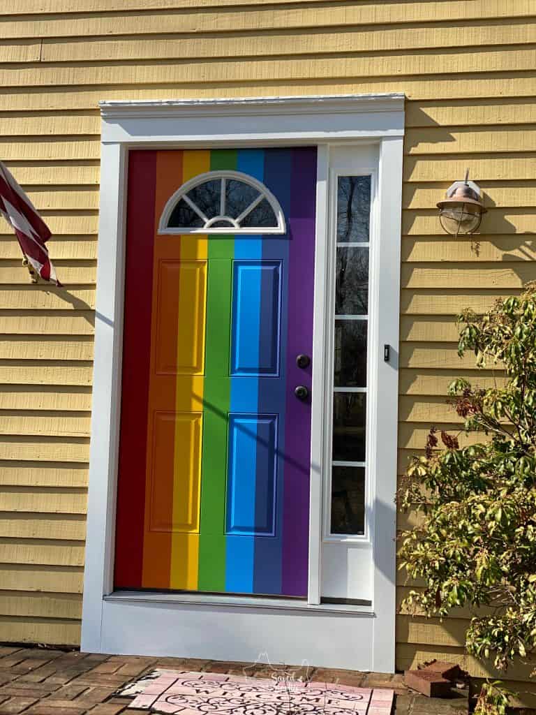 new painted door with rainbow pattern and fresh white trim. 
