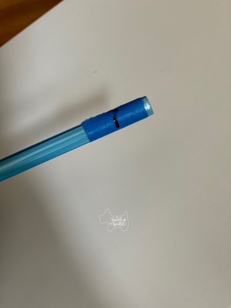 shell of mechanical pencil with painters tape marked for cutting  